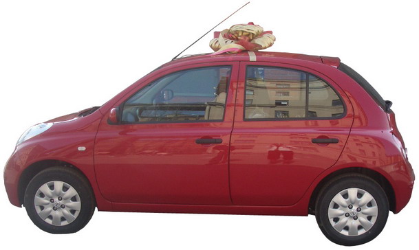 автомобиль Ниссан красного цвета с эксклюзивным золтым бантом на крыше, упаковка машин оформление авто бант на автомобиль
